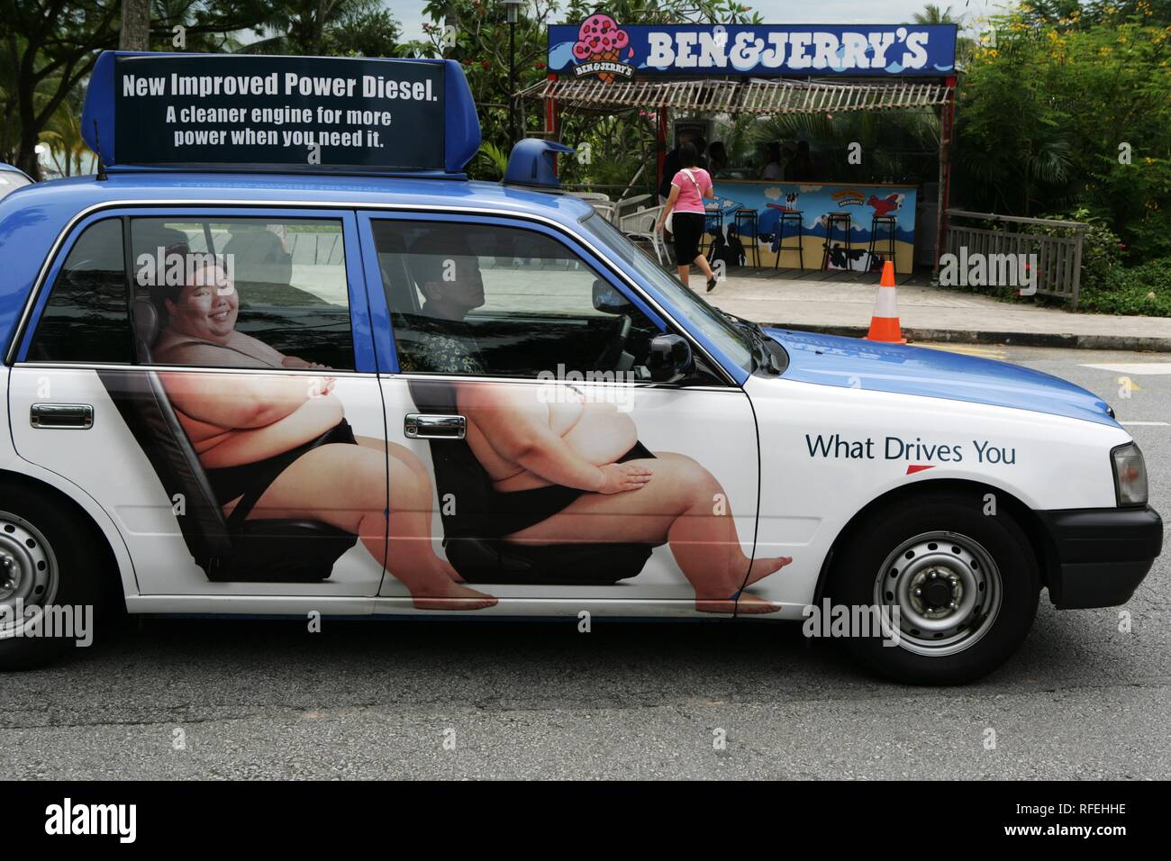 SGP, Singapore: Advertising with sumo wrestlers on a taxi. | Stock Photo