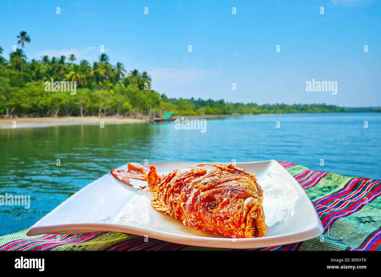 Cafes of the tourist village offer tasty local dishes, like fried spicy fish with herbs, Chaung Tha, Myanmar. Stock Photo