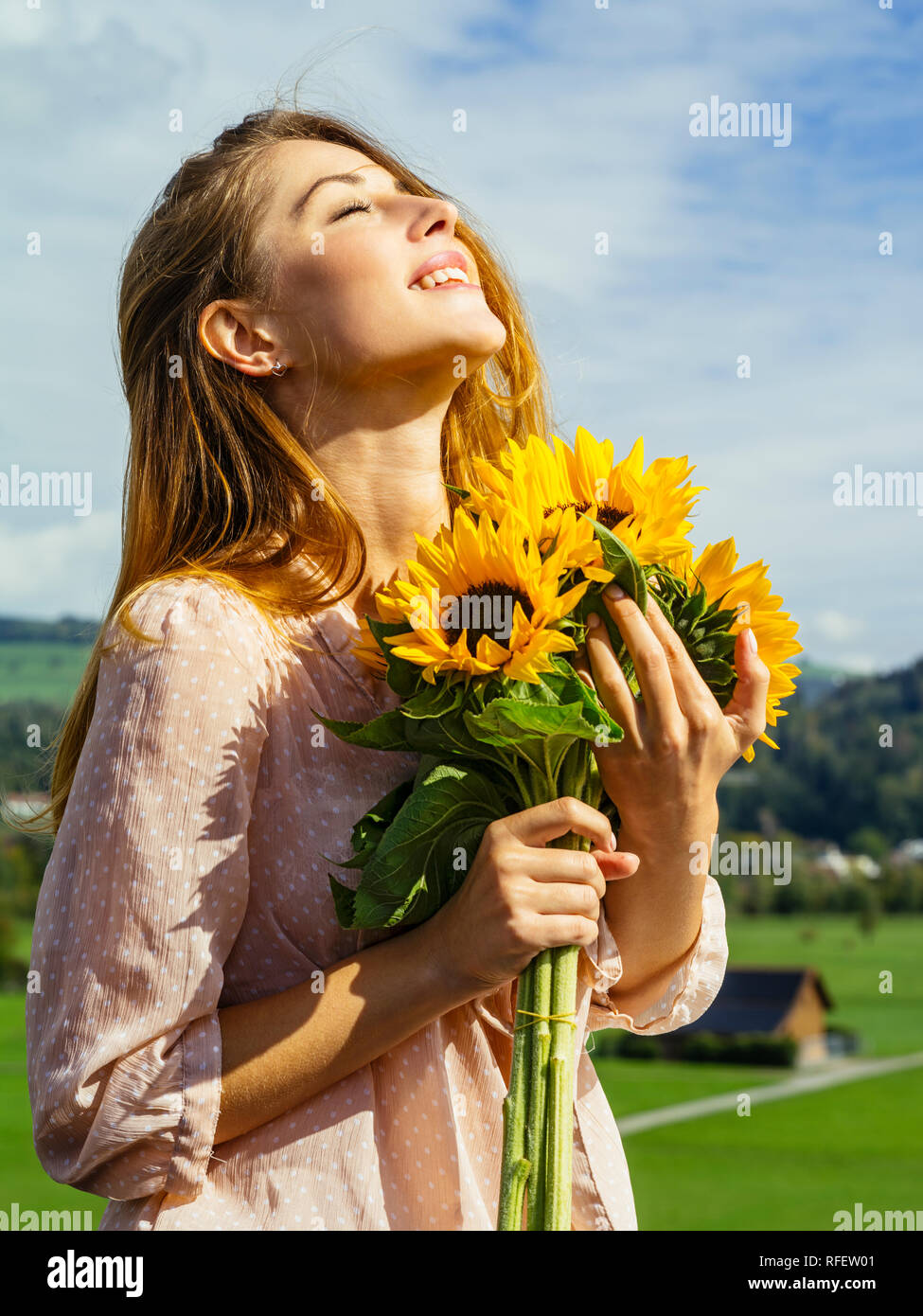 Photo of a happy young woman holding sunflowers in the sunshine Stock ...