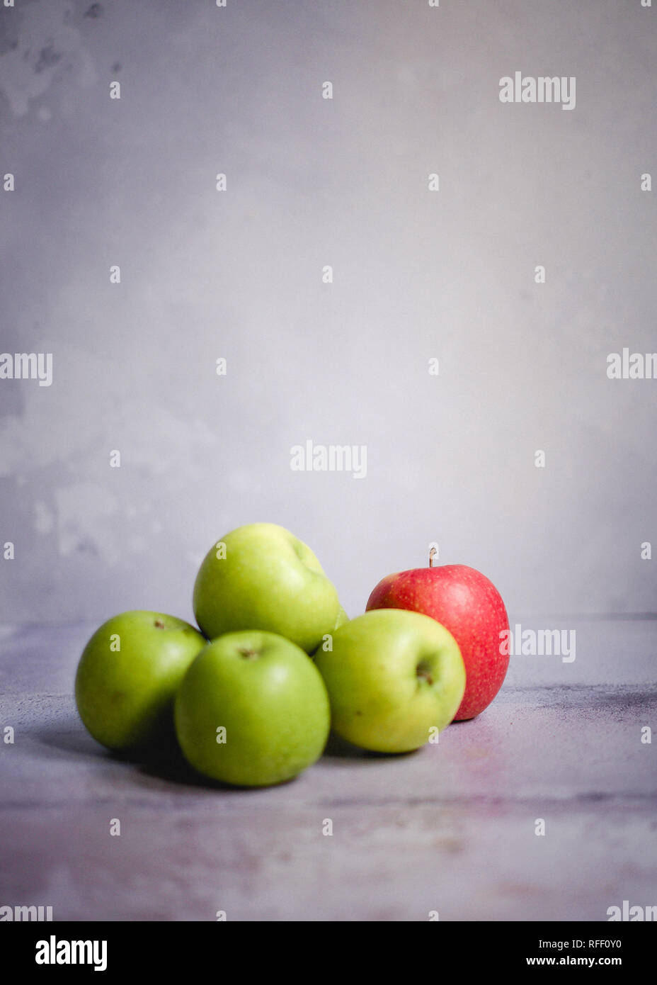 Four green apples and one red apple Stock Photo