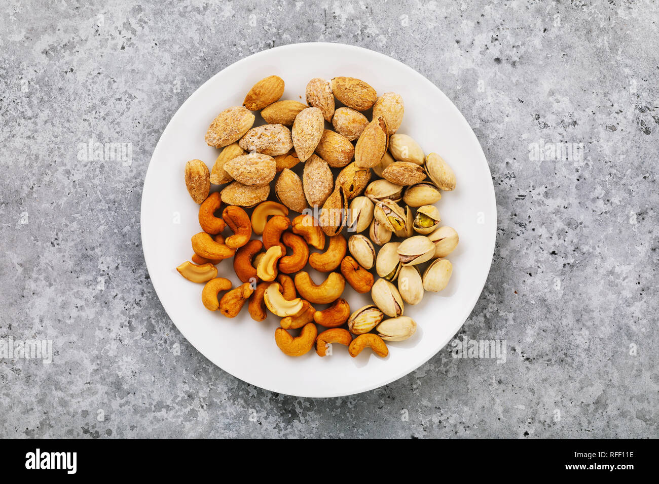 Nuts for beer in a white ceramic plate, top view Stock Photo