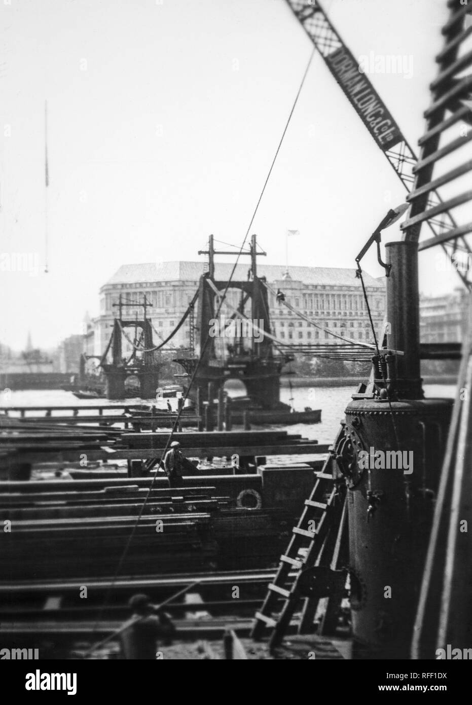The dismantling of the original Lambeth Bridge, over the River Thames, in London, England.This was modern bridge was a suspension bridge, 828 feet (252.4 m) long, designed by Peter W. Barlow. Sanctioned by an Act of Parliament in 1860, it opened as a toll bridge on 10 November 1862. Doubts about its safety, coupled with its awkwardly steep approaches deterring horse-drawn traffic, meant it soon became used almost solely as a pedestrian crossing. It ceased to be a toll bridge in 1879,  it was by then severely corroded, and was closed in 1910. Stock Photo