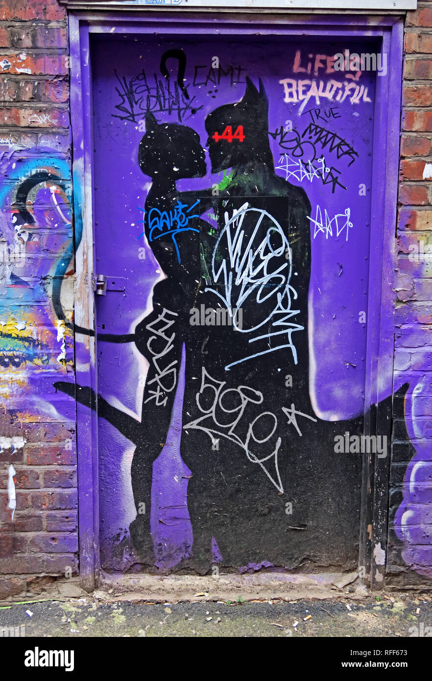Life is beautiful, Catwoman kisses Batman in a doorway, Northern Quarter, Manchester, NQ4, North West England, UK Stock Photo