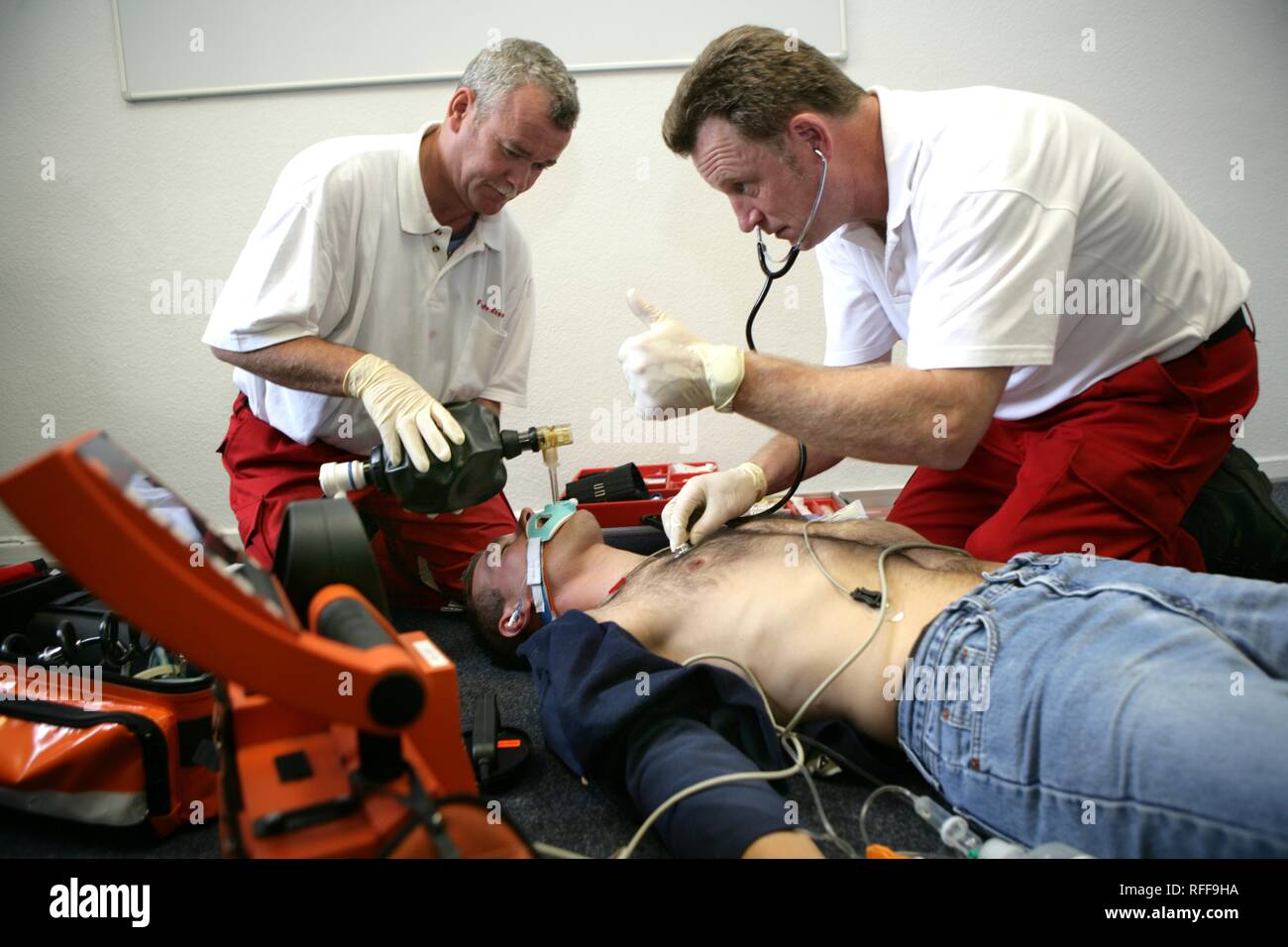 DEU Germany : Rescue paramedics in a private home attempt at resuscitation after a cardiac arrest. Training situation. | Stock Photo