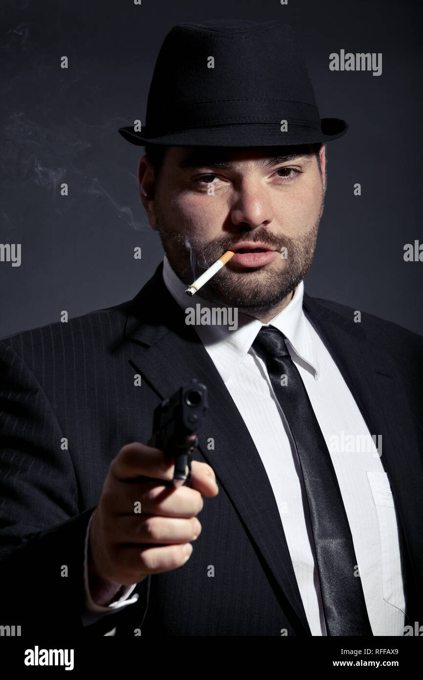 Dangerous man in suit with a gun Stock Photo