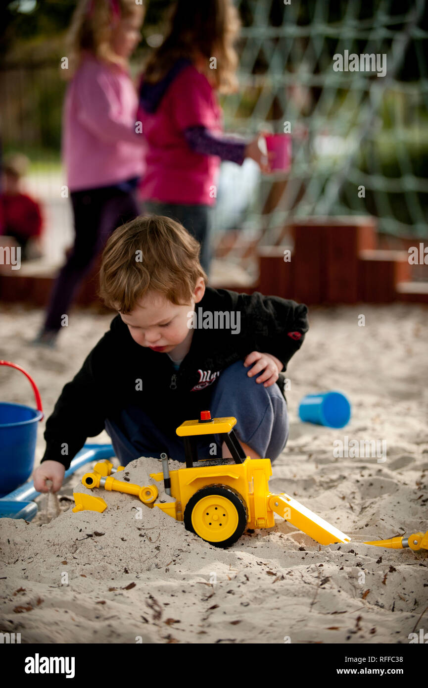 Toddler playing in a sand pit Stock Photo