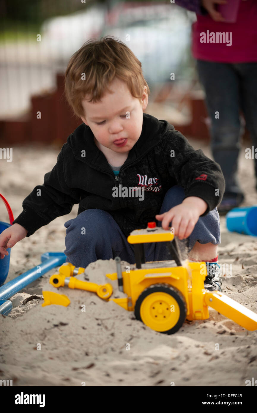 Toddler playing in a sand pit Stock Photo