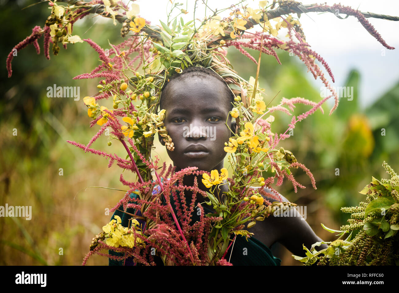 KIBISH, ETHIOPIA - AUGUST 22, 2018: unidentified woman from Surmi tribe, with  natural decorations of leave and flowers in a wreath. Surmi are also ca Stock Photo