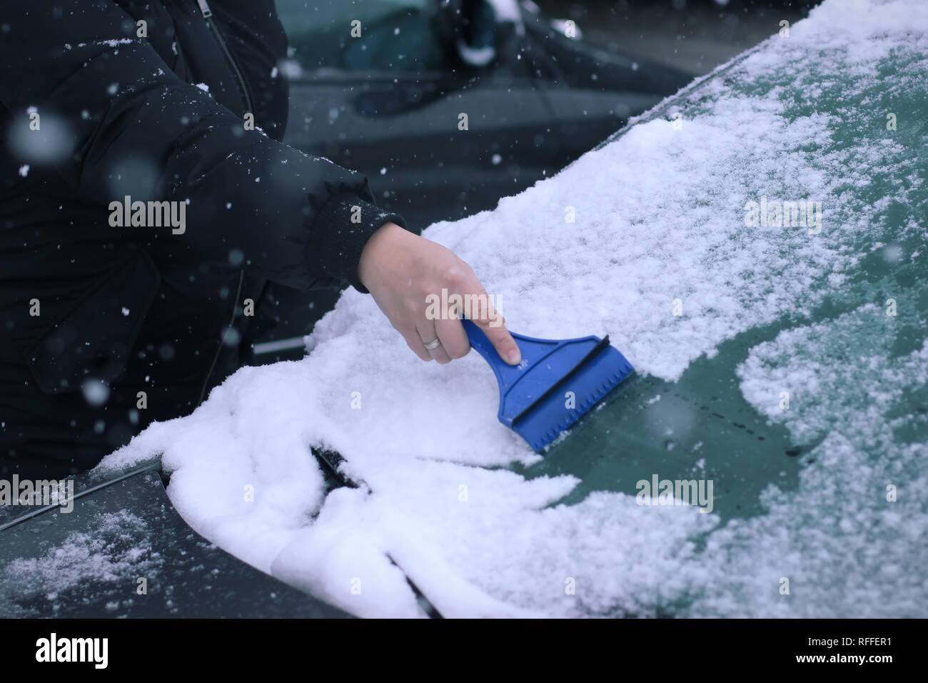 Female driver cleaning snow from windshield Stock Photo Alamy