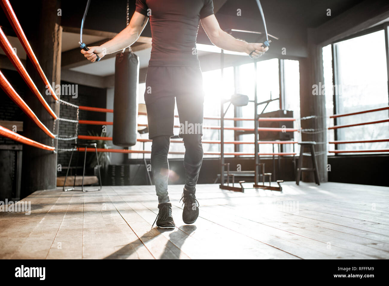 Young Athletic Man In Black Uniform Training With A Jumping Rope