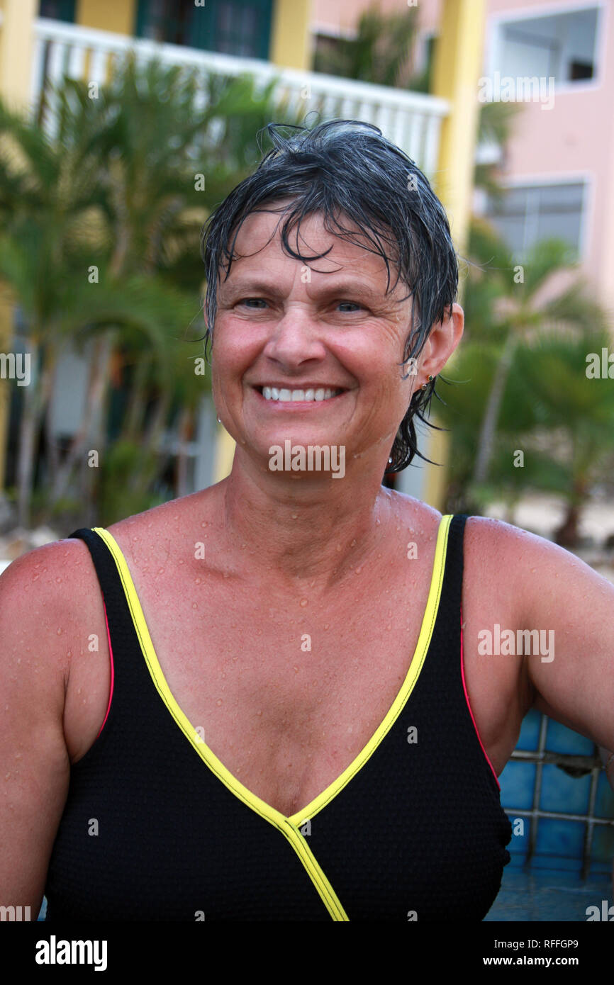 Woman in a swimsuit smiling by an outdoor pool Stock Photo