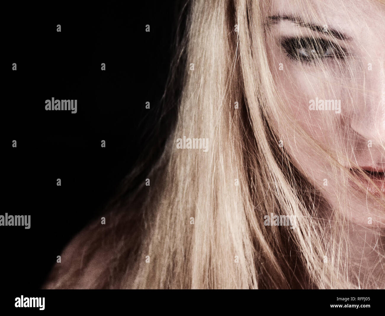 Pretty young woman with serious expression and hair over face Stock Photo