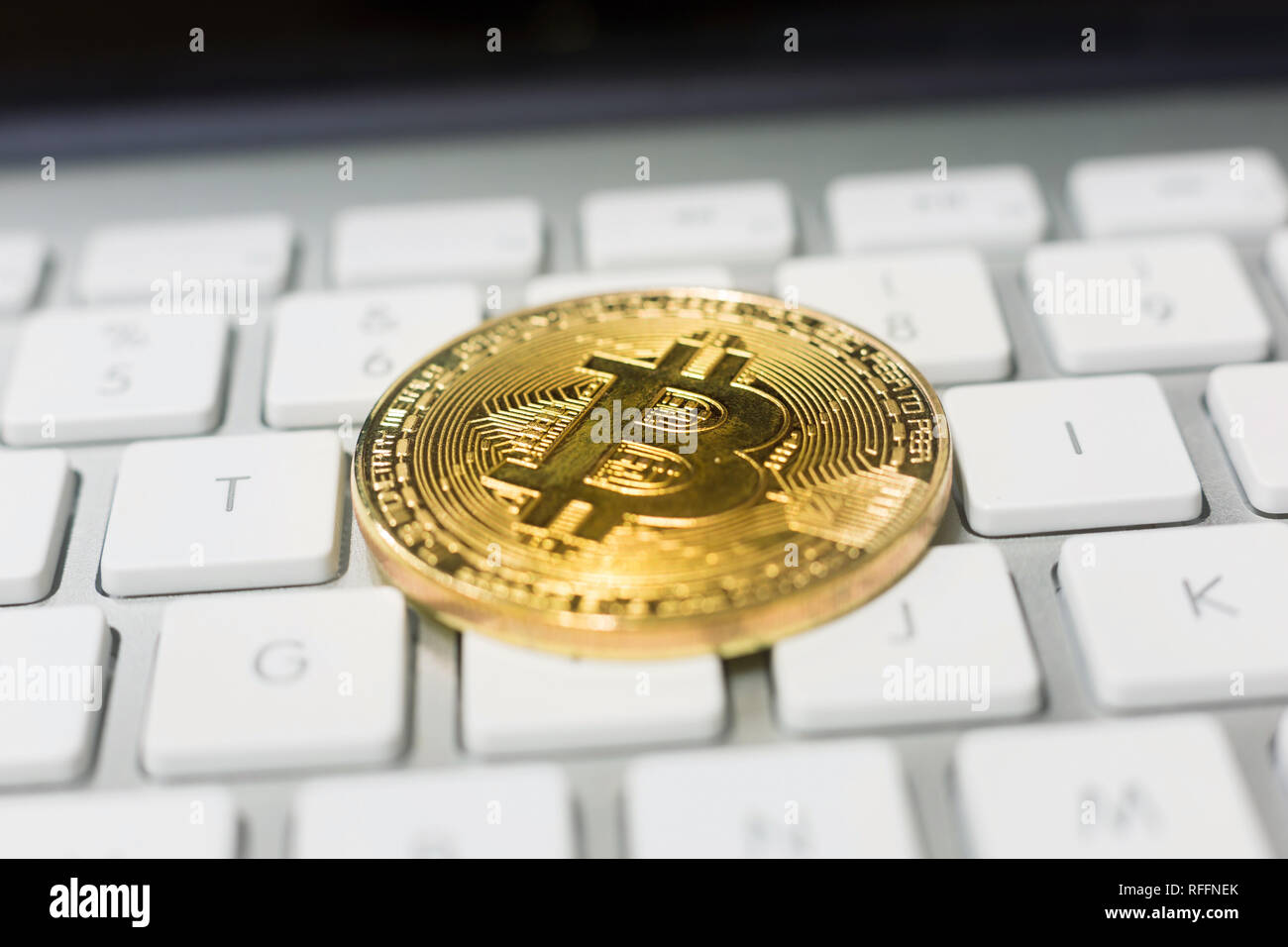 Bitcoin crypto coin placed on a minimalist white computer keyboard ...