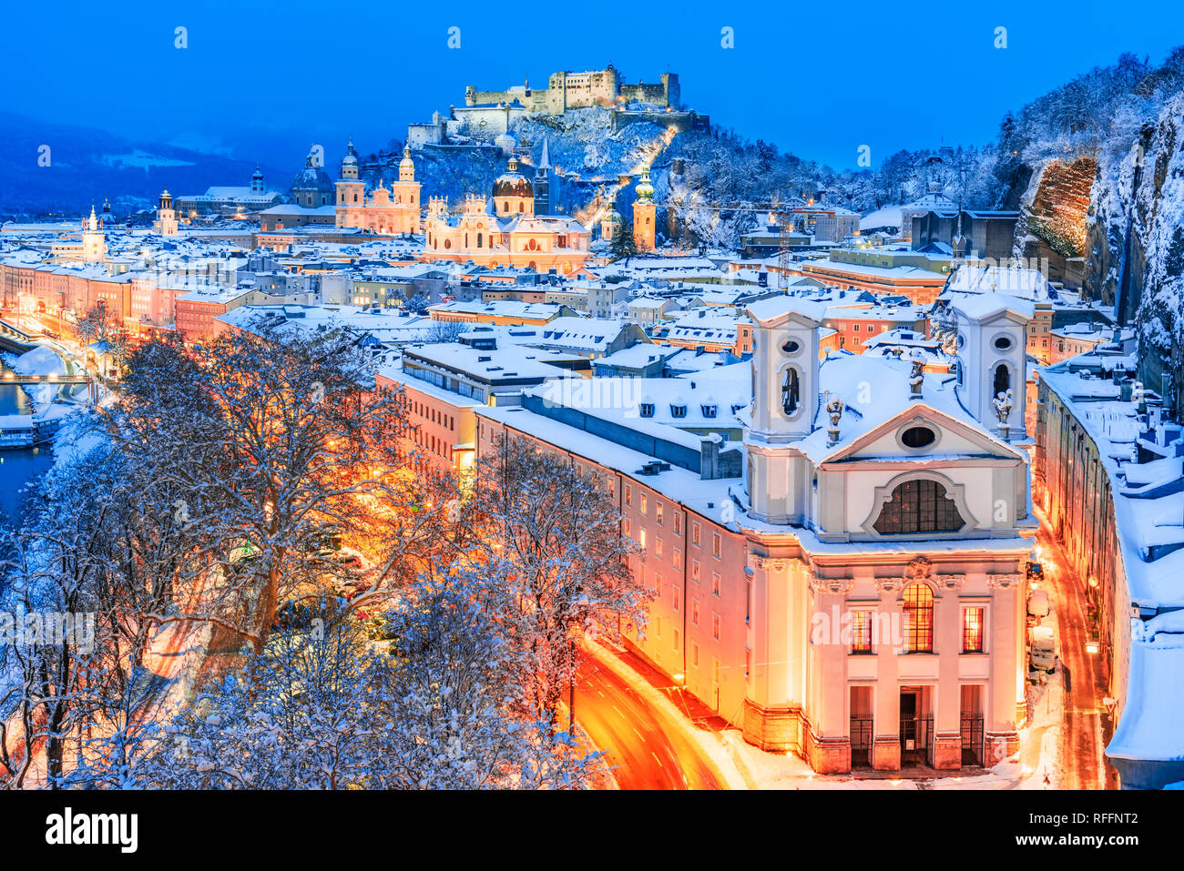 Salzburg, Austria: Winter viewof the historic city of Salzburg with famous Festung Hohensalzburg and Salzach river illuminated in beautiful twilight Stock Photo