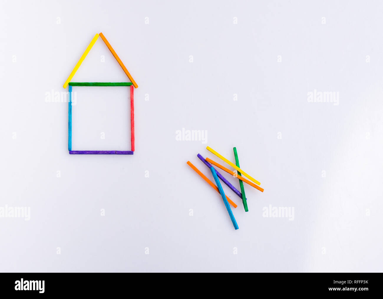 A house made of colorful sticks with a bunch of more sticks Stock Photo ...