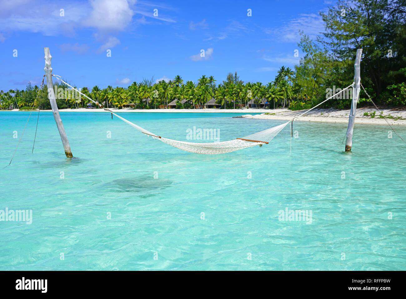Hammock with a view, planted in the azure waters of the Bora Bora lagoon, French Polynesia Stock Photo
