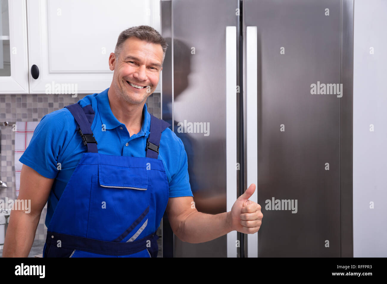 Happy Mature Male Technician Gesturing Thumbs Up Sign Stock Photo