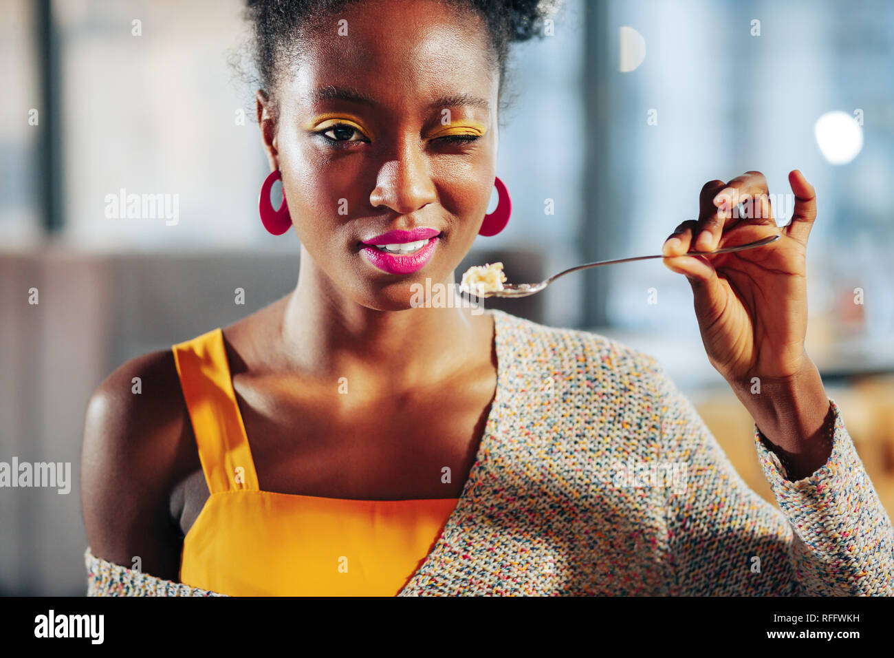 African-American woman with bright pink lips eating dessert Stock Photo