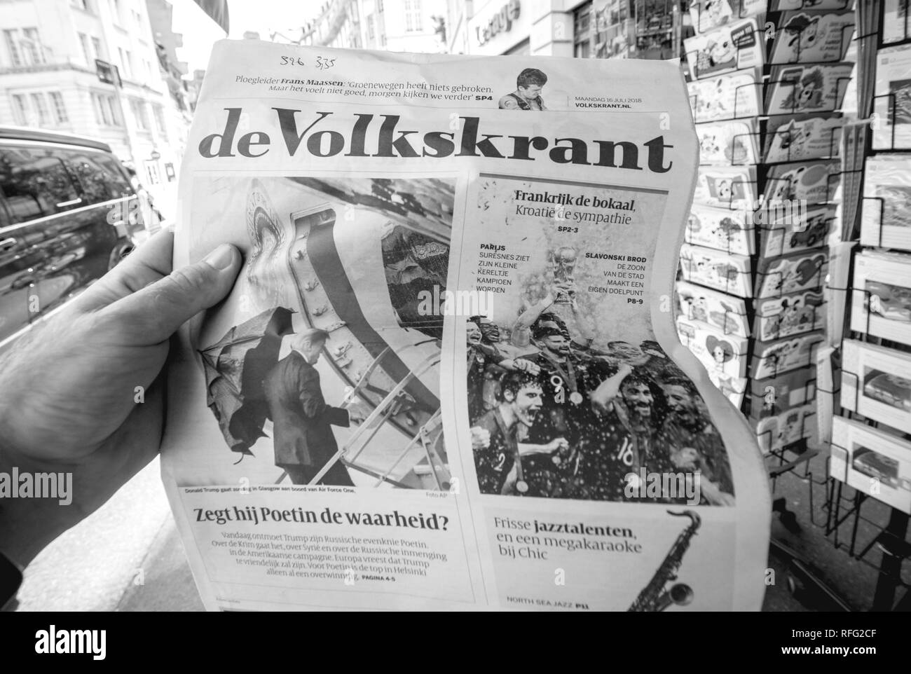 PARIS, FRANCE - JUL 16, 2018: Man buying De Volkskrant dutch newspaper announcing France champion title after French national football team won their  Stock Photo