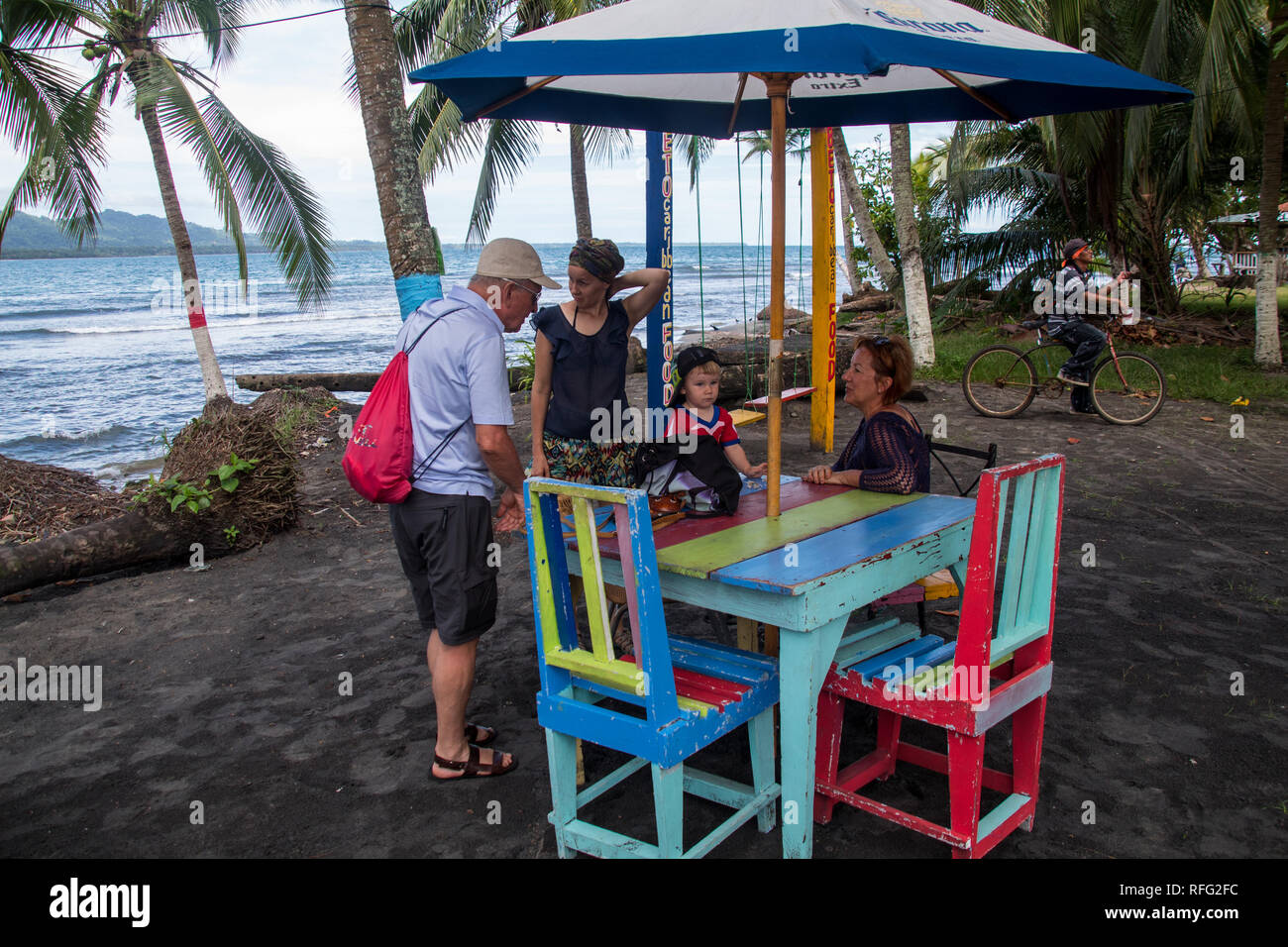 A photo of a family having a break on beautiful colorful furniture of a beach bar in Puerto Viejo, Costa Rica Stock Photo