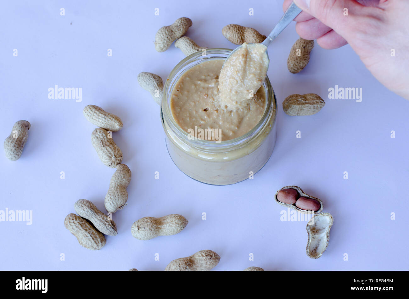 https://c8.alamy.com/comp/RFG4BM/homemade-peanut-butter-in-glass-jar-with-peanuts-spread-on-the-table-RFG4BM.jpg