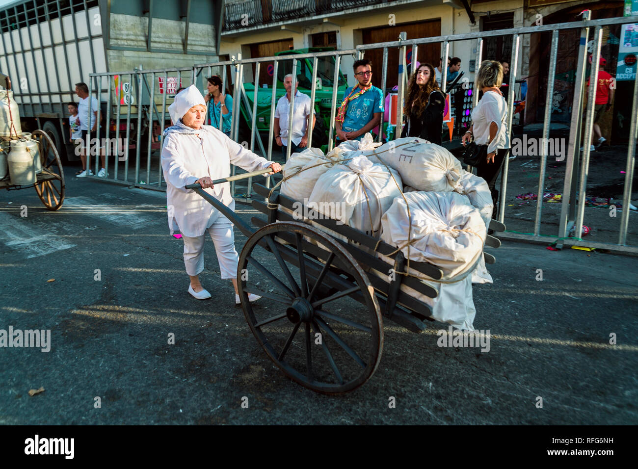 French lady pushing sacks of flour on cart  in Old School Parade of traditional trades at Annual Fete, Saint Gilles, Gard, France Stock Photo
