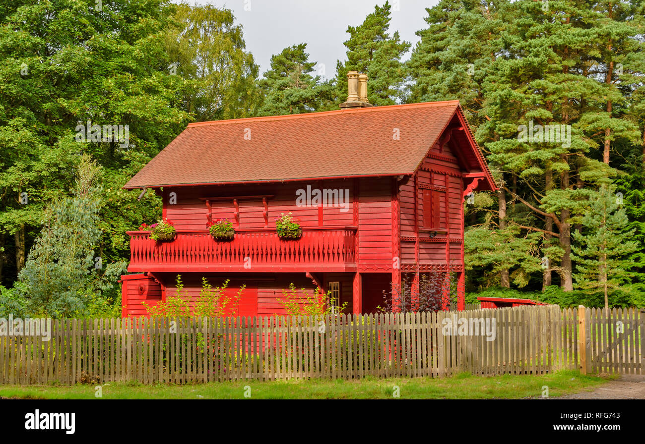 RED CHALET HOUSE GORDON CASTLE ESTATE FOCHABERS SCOTLAND SURROUNDED BY SCOTS PINE TREES Stock Photo