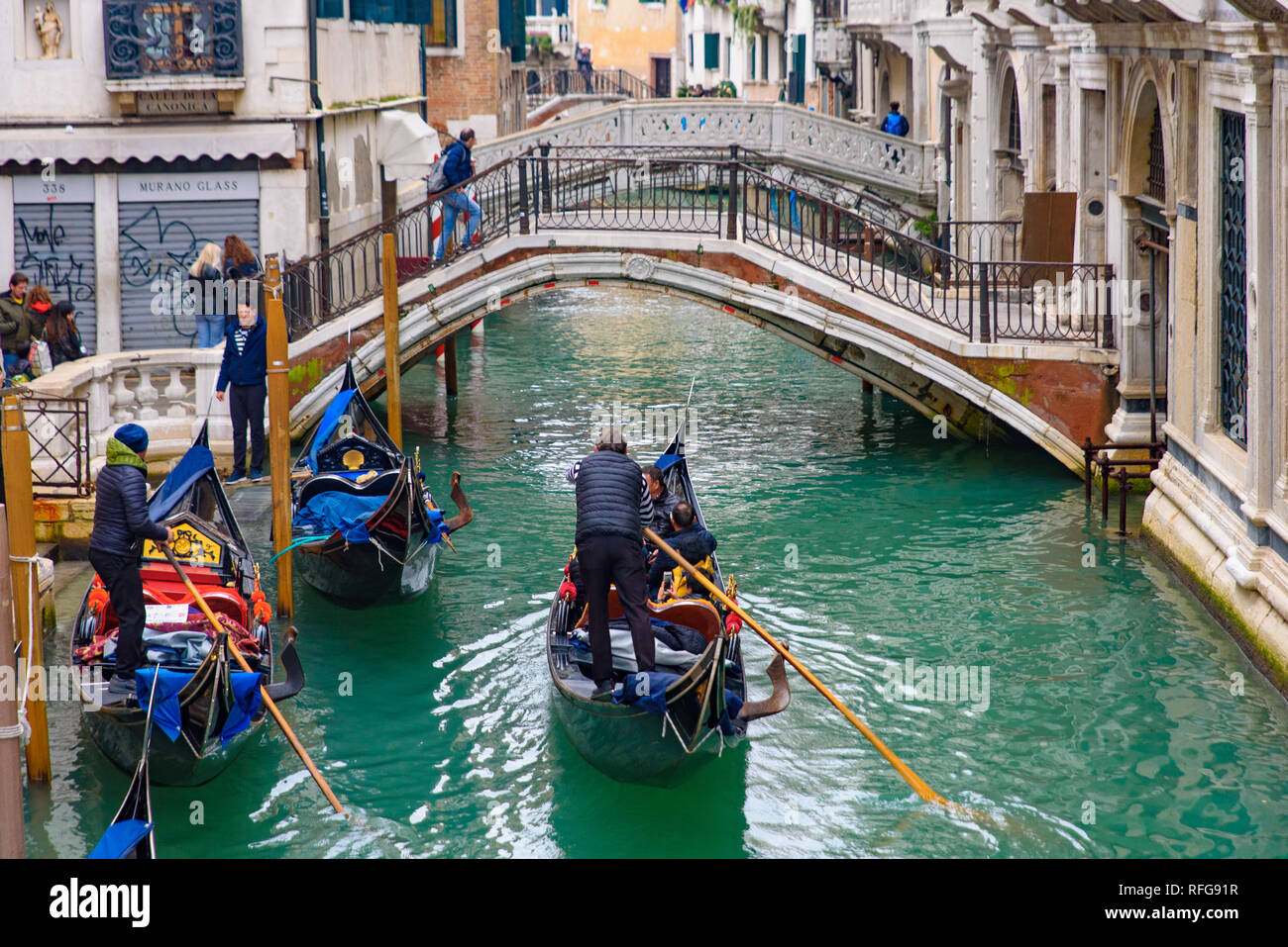 Gondola, the traditional boat, on canal with tourists, Venice
