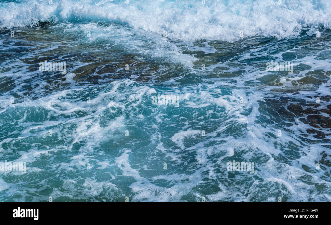 surface of the blue sea water with white foam on sunny day - wave ...