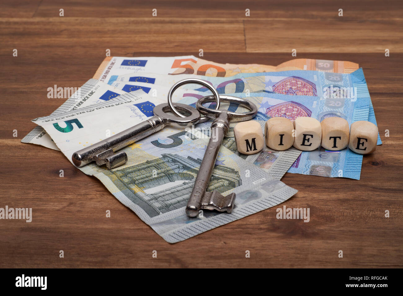 Die Euro Geldscheine Münzen und Schlüssel liegen auf dem Tisch mit dem Wort Miete. Stock Photo