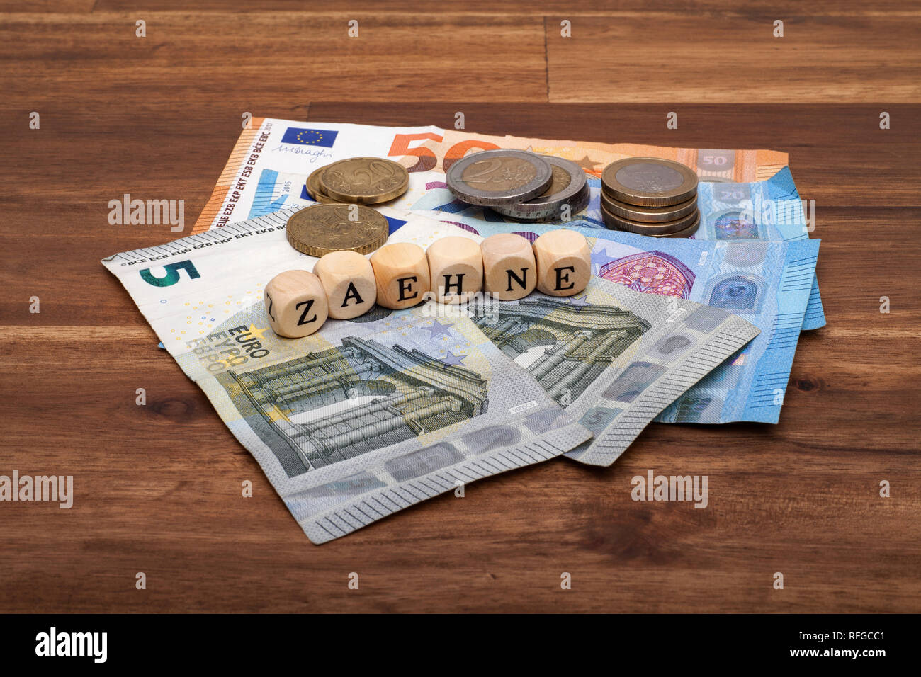 Die Euro Geldscheine und Münzen liegen auf dem Tisch mit dem Wort Zähne Stock Photo
