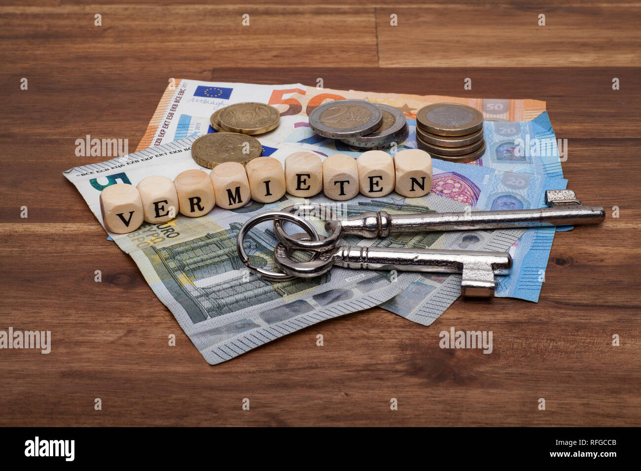Die Euro Geldscheine Münzen und Schlüssel liegen auf dem Tisch mit dem Wort Vermieten Stock Photo