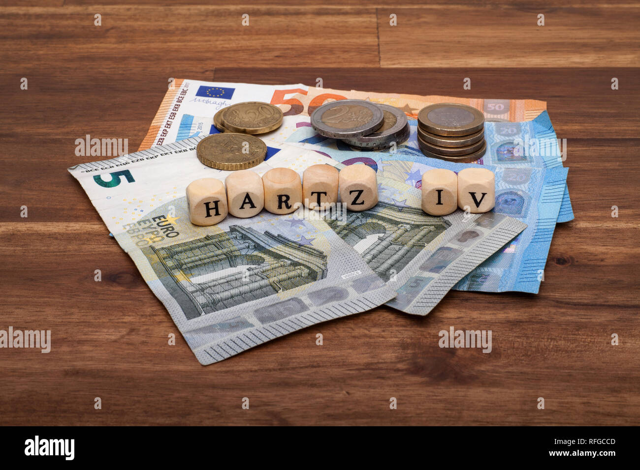 Die Euro Geldscheine und Münzen liegen auf dem Tisch mit dem Wort Hartz IV Stock Photo