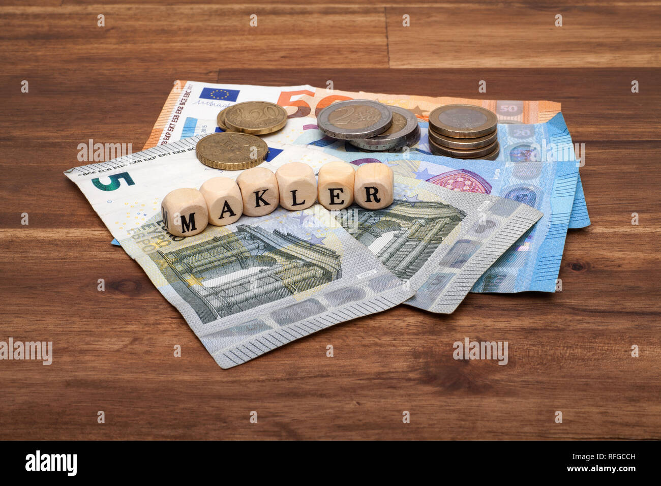 Die Euro Geldscheine Münzen und Schlüssel liegen auf dem Tisch mit dem Wort Makler Stock Photo