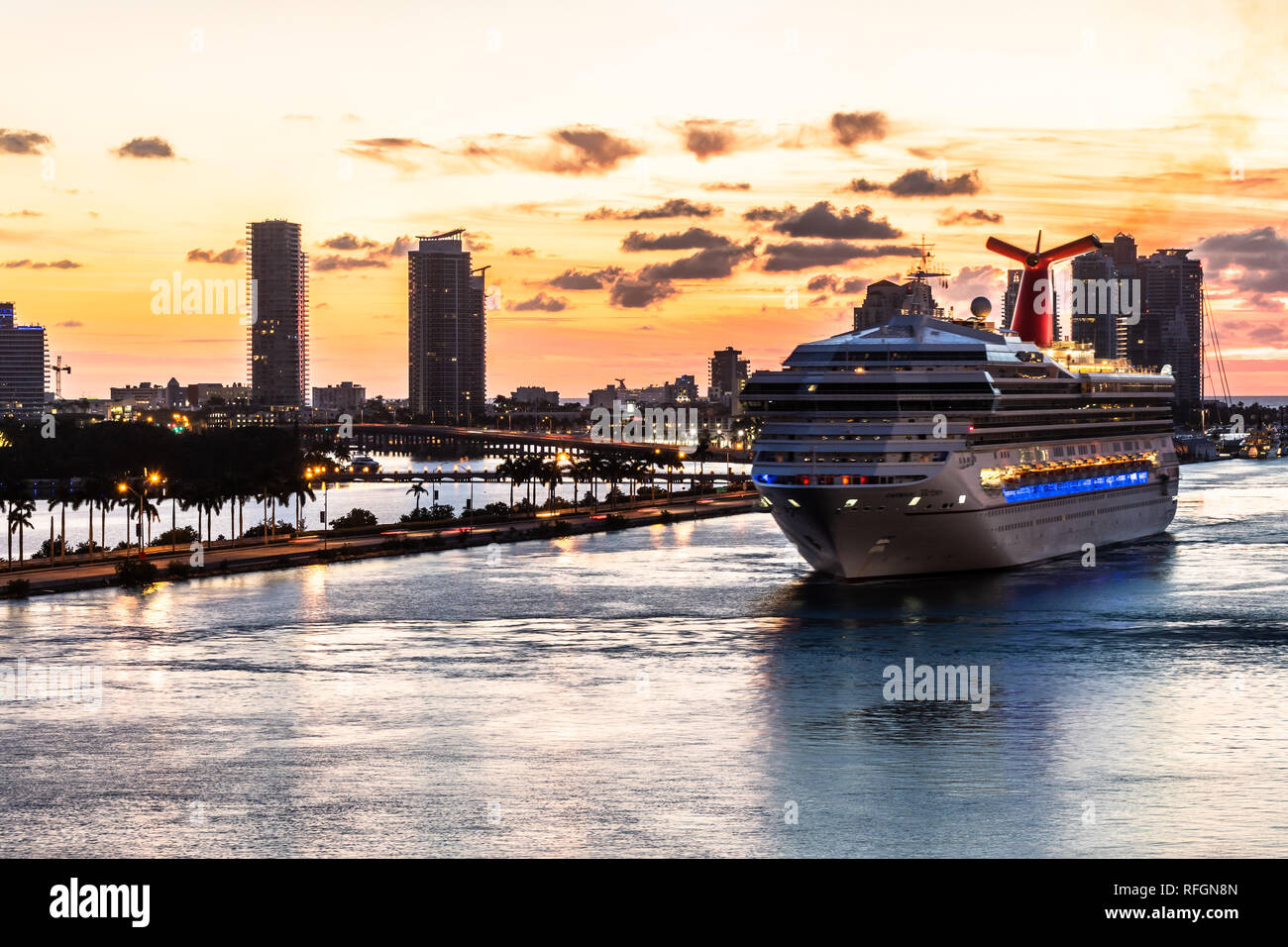 Miami, Florida - November 19 2018: Amazing sunrise skyline view of the city of Miami with Carnival Victory Cruise Ship sailing into the Port of Miami Stock Photo