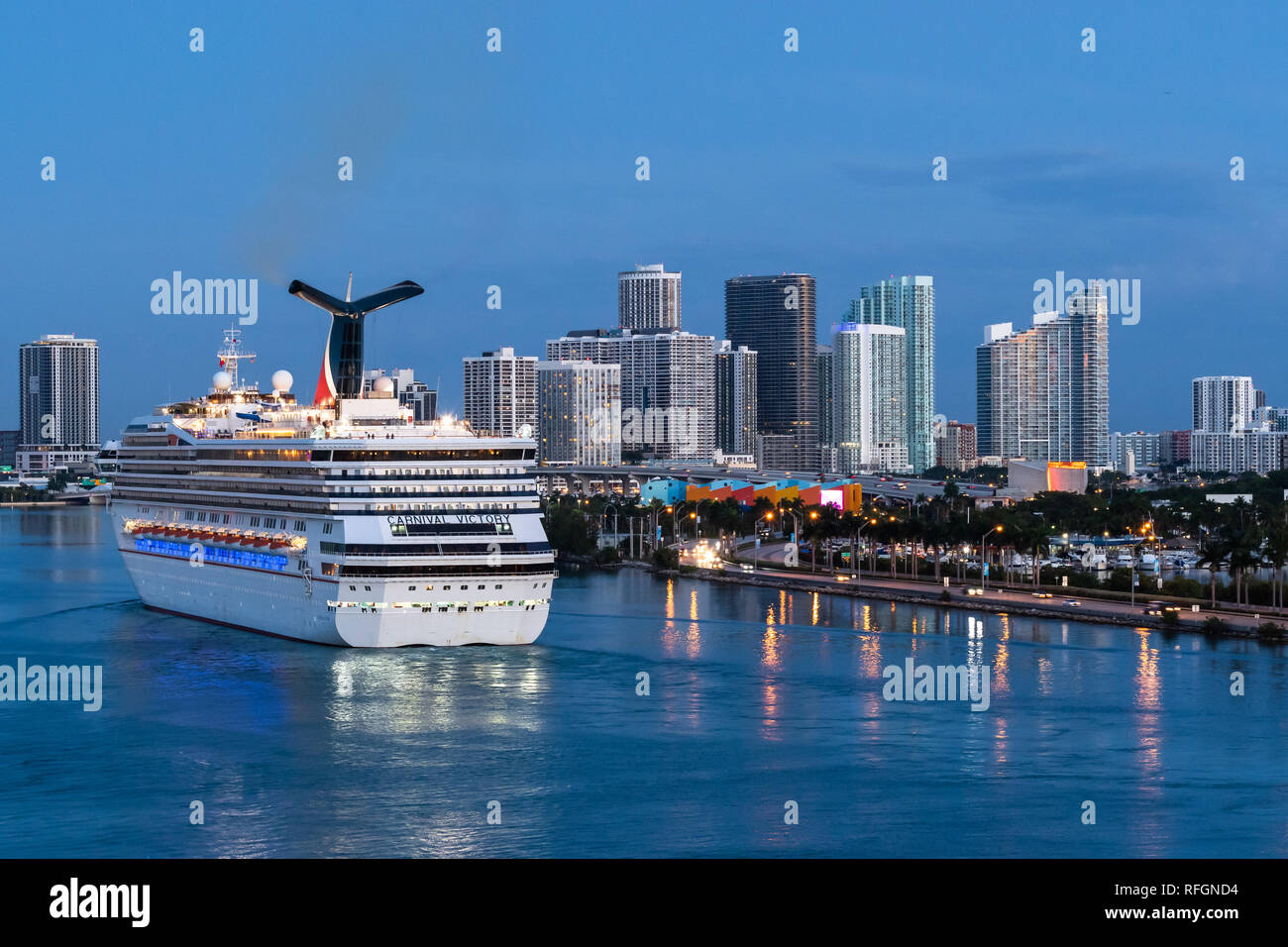 Miami, Florida - November 19 2018: Carnival Victory Cruise Ship sailing in the Port of Miami at sunrise with skyline of downtown Miami in the backgrou Stock Photo