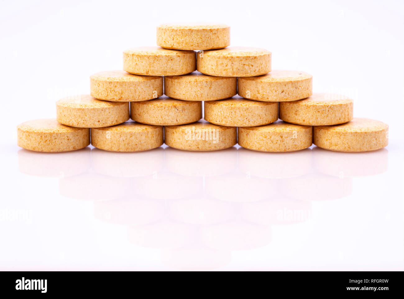 Beige pills isolated on white reflective background. Global