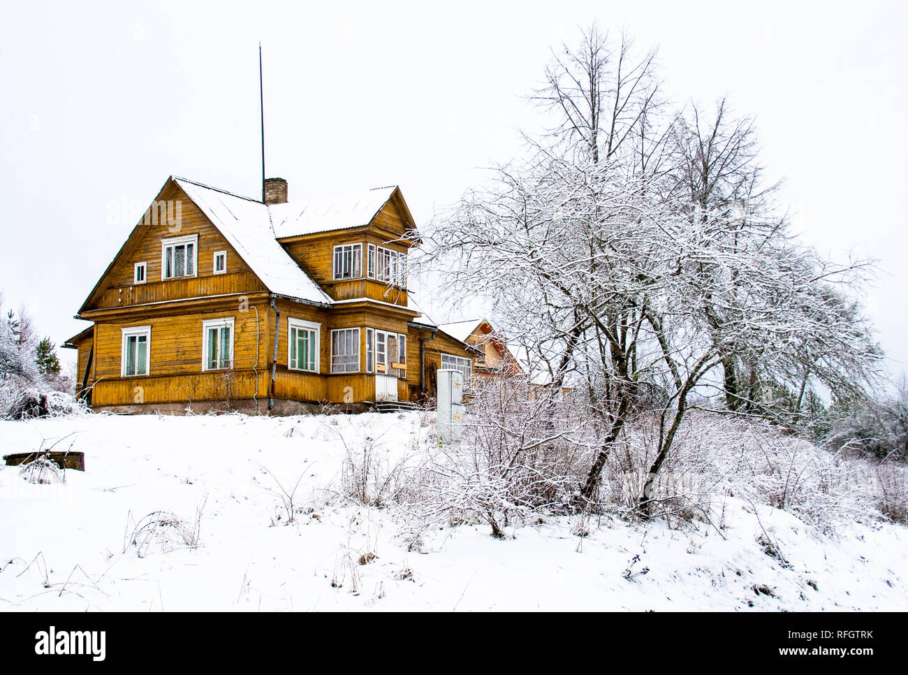 Wooden house in the wood in winter, with snow and tree, Lithuania Stock