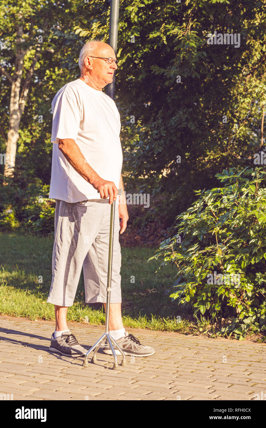 senior man with his walking stick in park Stock Photo