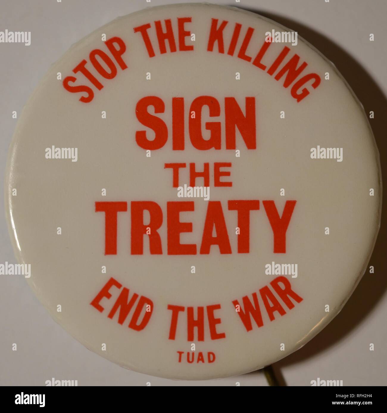 White and red, anti-war, pin-back button or badge, with the text 'Stop The Killing, Sign The Treaty, End the War,' referring to the Paris Peace Accords or the Agreement on Ending the War and Restoring Peace in Vietnam, with 'TUAD,' possibly an acronym for the group which produced the pin, in smaller text at the bottom of the button, manufactured during the Vietnam War, 1973. () Stock Photo
