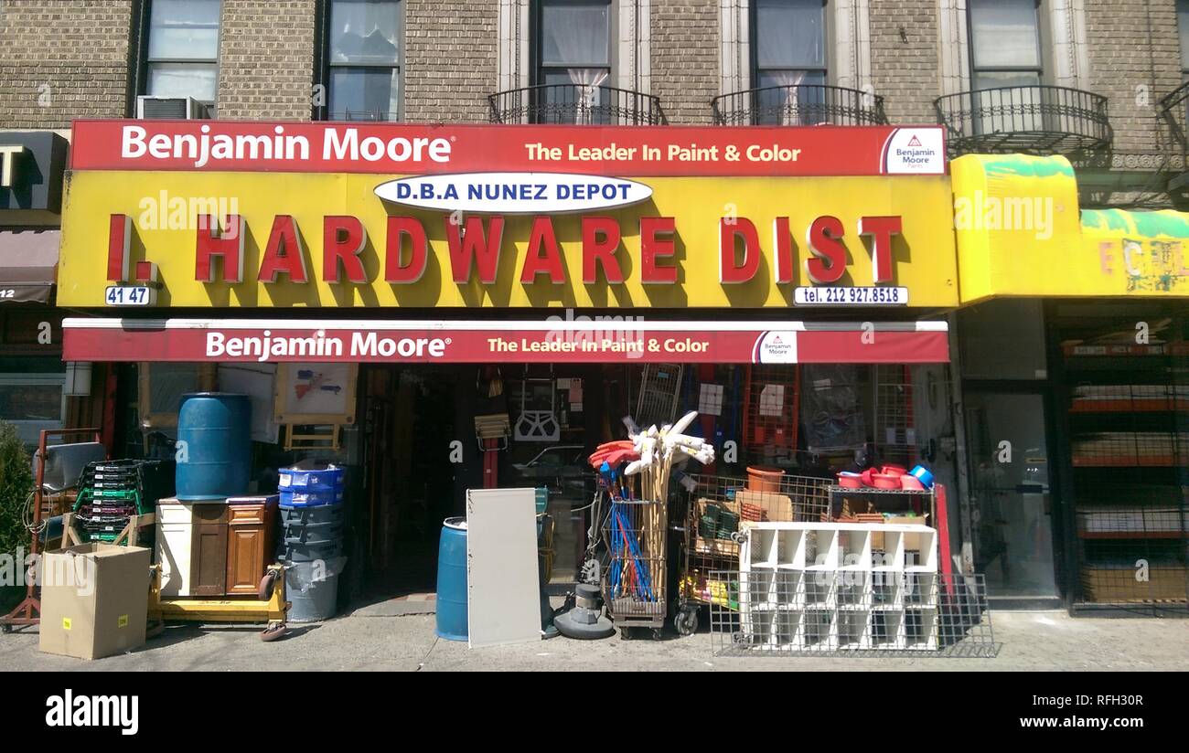 Facade with large stacks of assorted hardware materials and sign reading Nunez Depot Hardware, as well as logos for Benjamin Moore paint, at a family run hardware store on Broadway in Washington Heights, New York City, New York, 2015. () Stock Photo