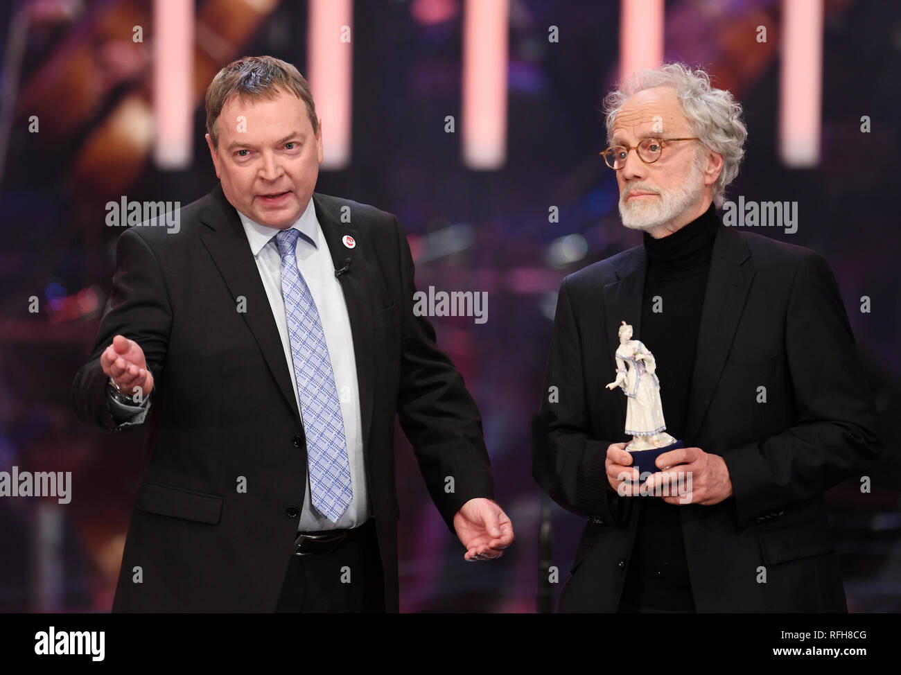 25 January 2019, Bavaria, München: Markus Imhoof (r), Swiss film director, receives his award from Claus-Peter Reisch, captain of the Lifeline rescue ship, at the Bavarian Film Award ceremony in the Prinzregententheater. Imhoof was awarded the documentary film prize for the film 'Eldorado'. Photo: Tobias Hase/dpa Stock Photo