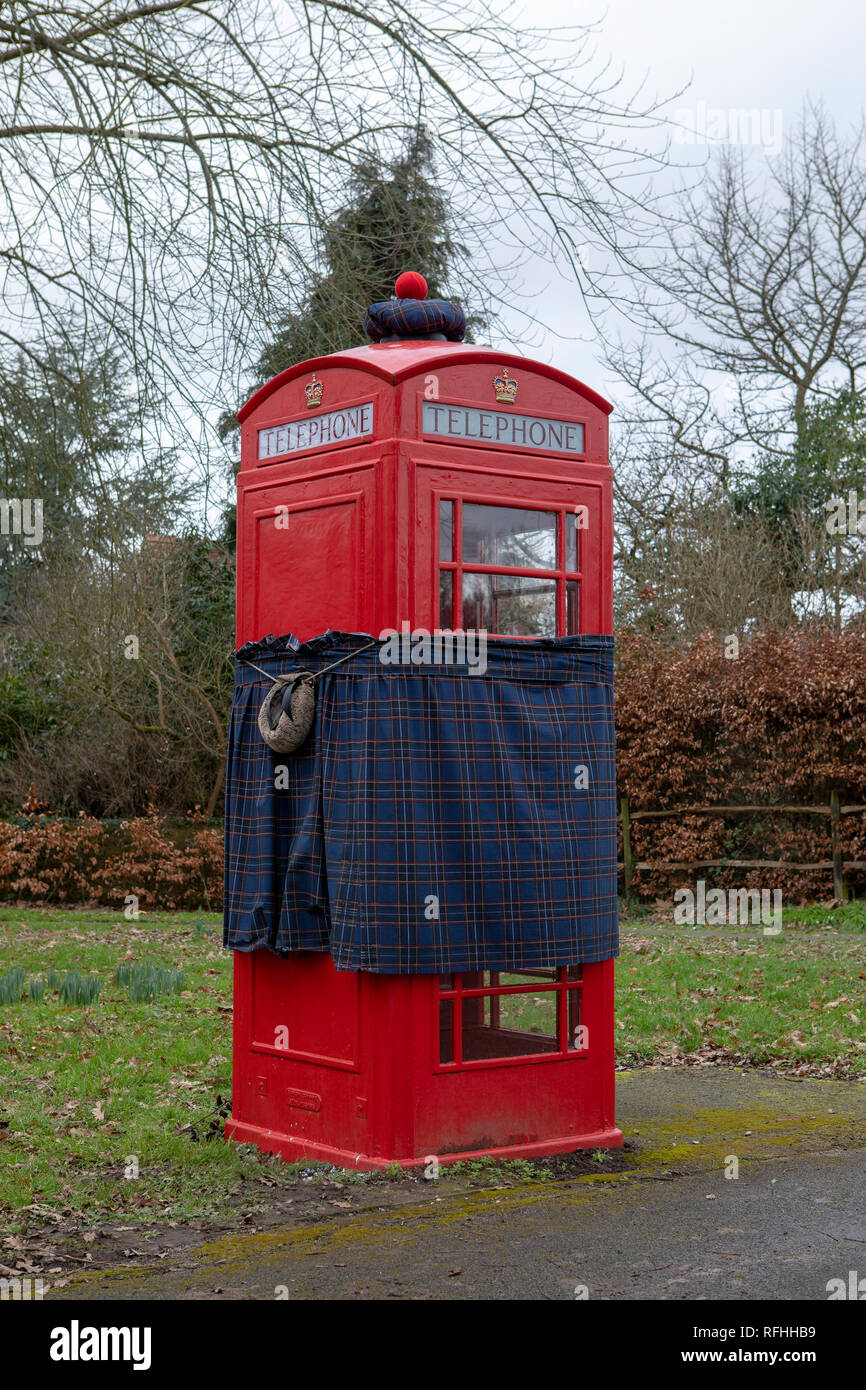 Red telephone box gets the Robbie Burns makeover. Sporting a kilt, sporran and hat looking better than most after a heavy night. Stock Photo