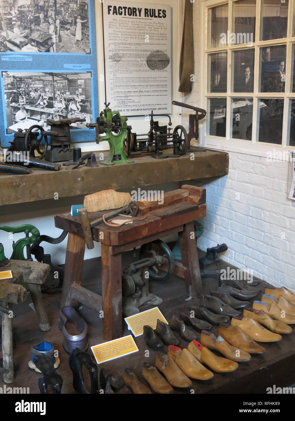 Photo of rows of shoe lasts, tools and a workman's bench in a display