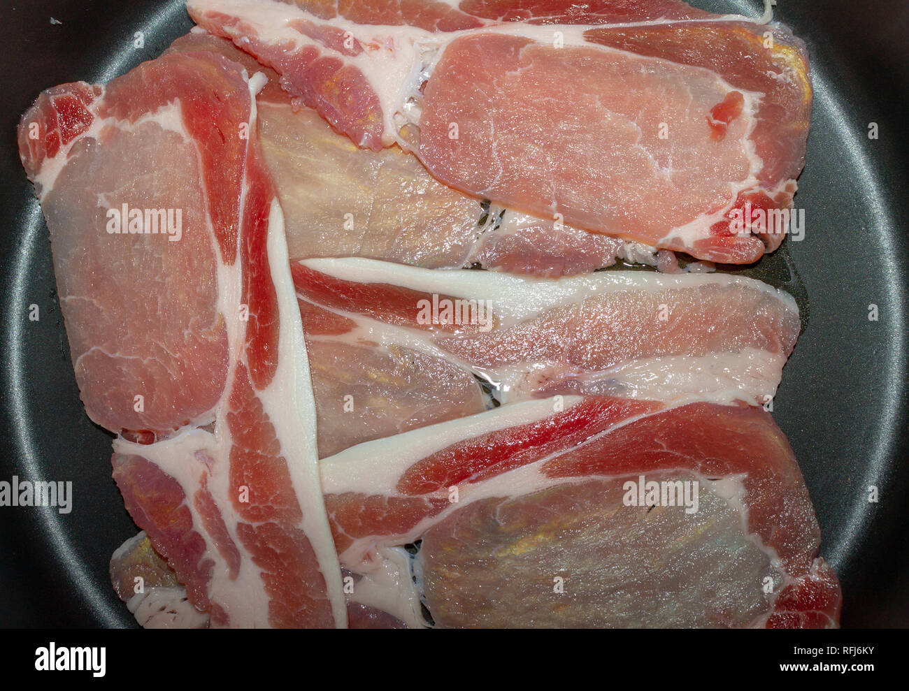 close up of slices of bacon or rashers in a frying pan Stock Photo