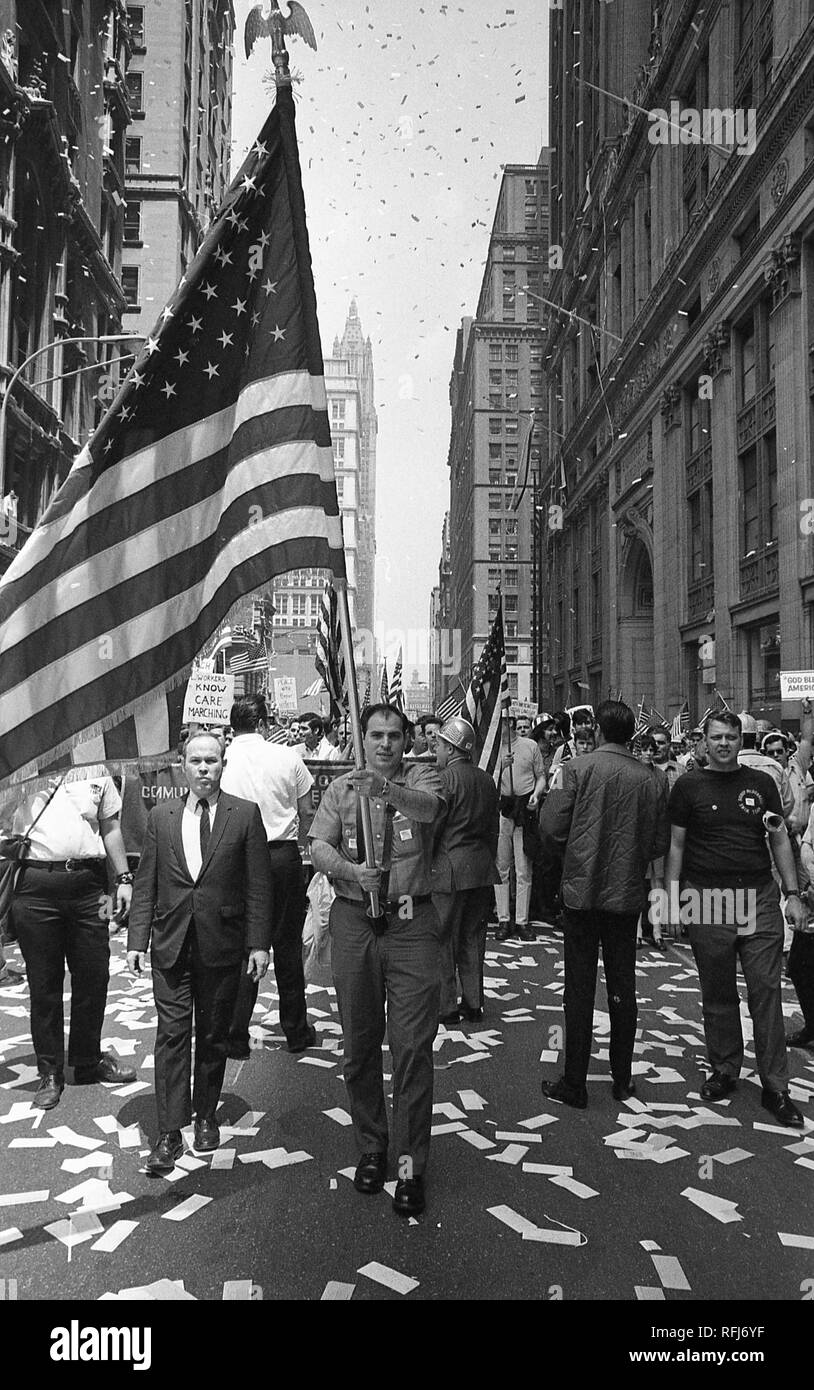 Demonstrators march and hold banners and flags while participating in