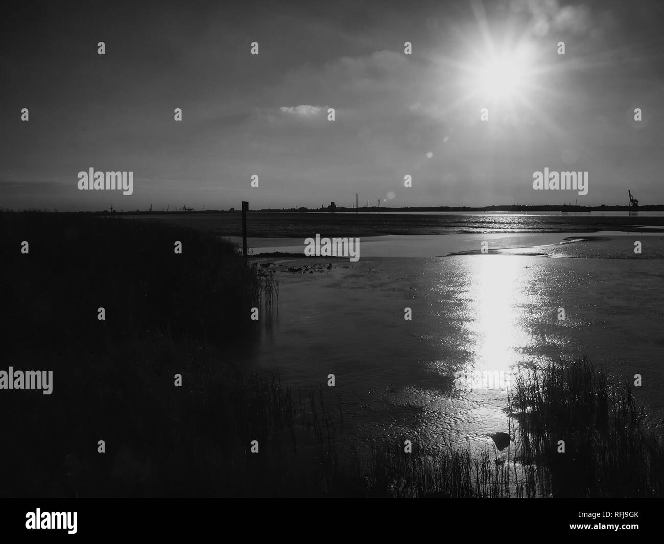 Monochrome image of mudflats in the estuary of Weser river near Nordenham at backlight Stock Photo
