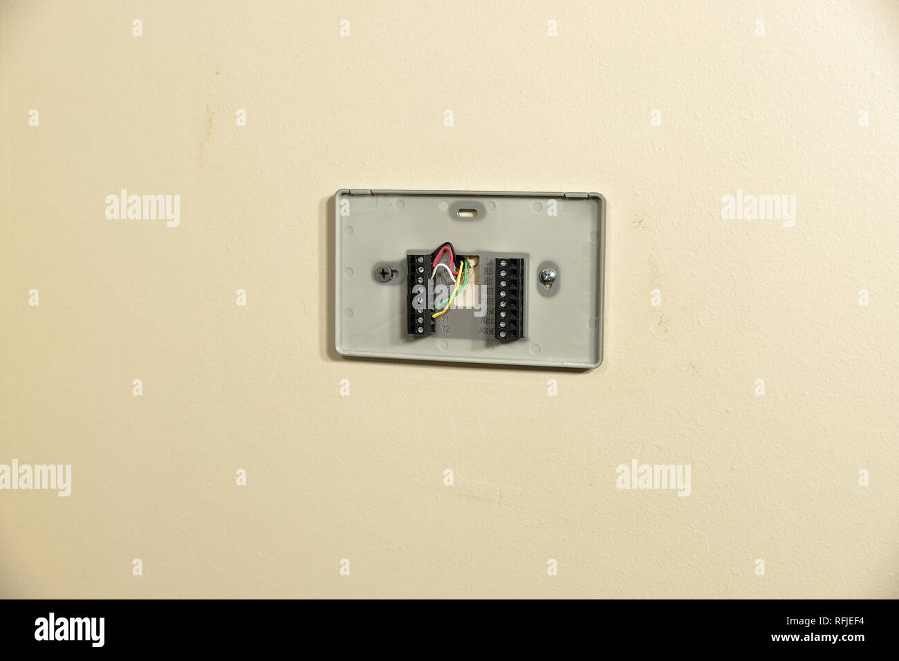 Thermostat wiring plate on wall for installation Stock Photo