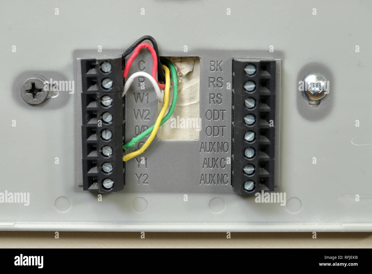 Close-up of thermostat wiring on wall, with colored wires Stock Photo