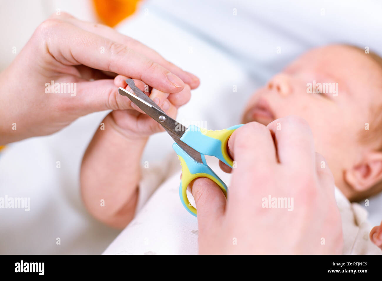 Close up of mother cutting babies nails with scissors. Nursing a child  Stock Photo - Alamy